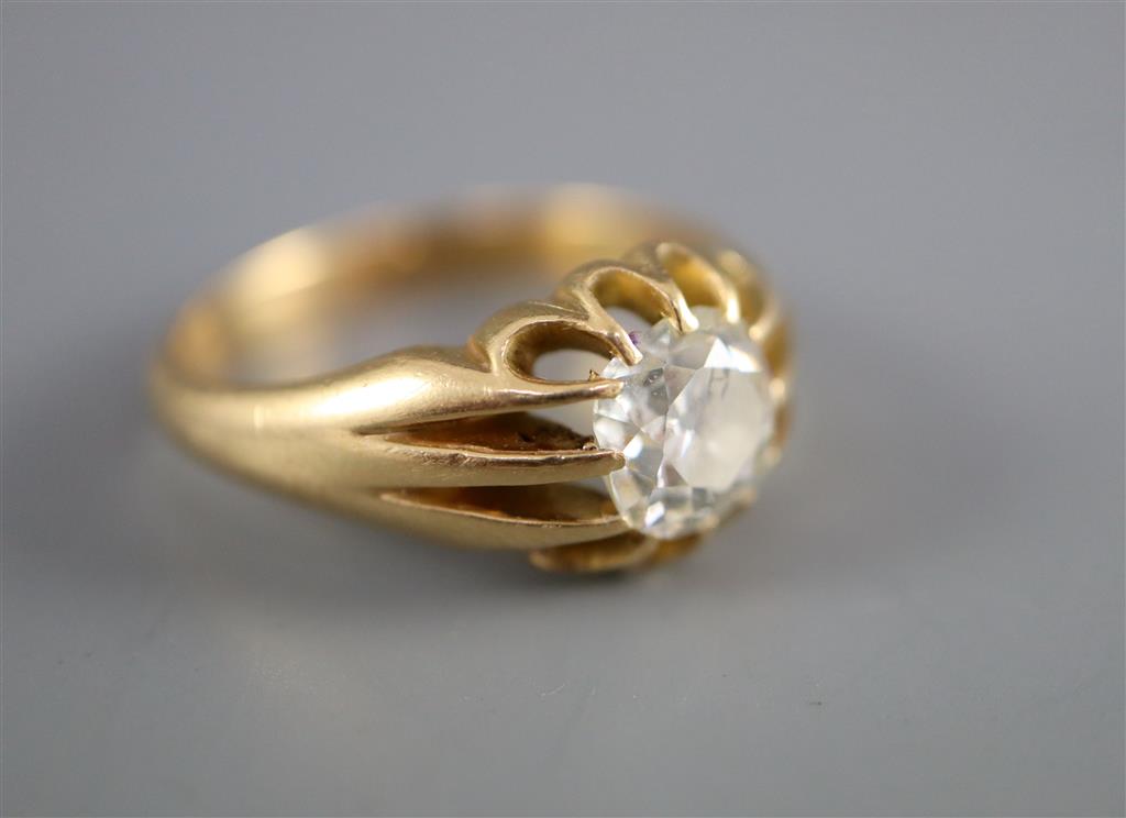 An early 20th century gold and old cushion cut claw set solitaire diamond ring, with fluted shoulders,